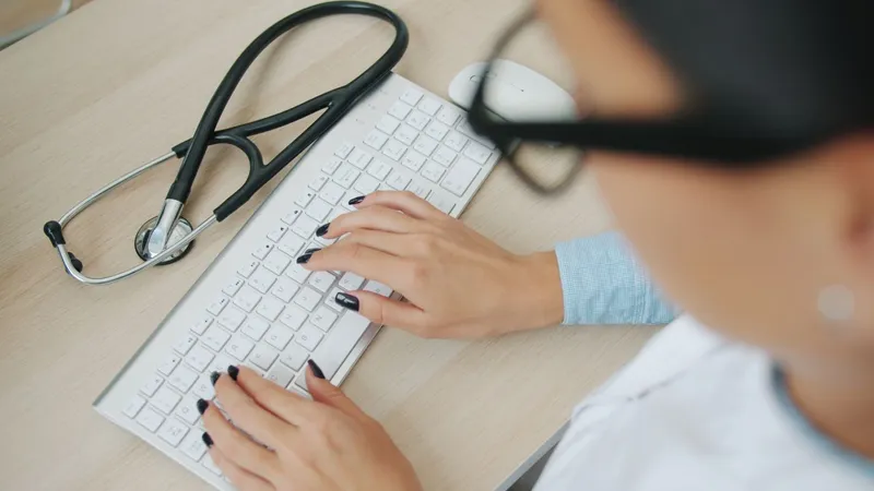 Doctoriţă document&acirc;ndu-se pe laptop - Pexels/Vitaly Gariev