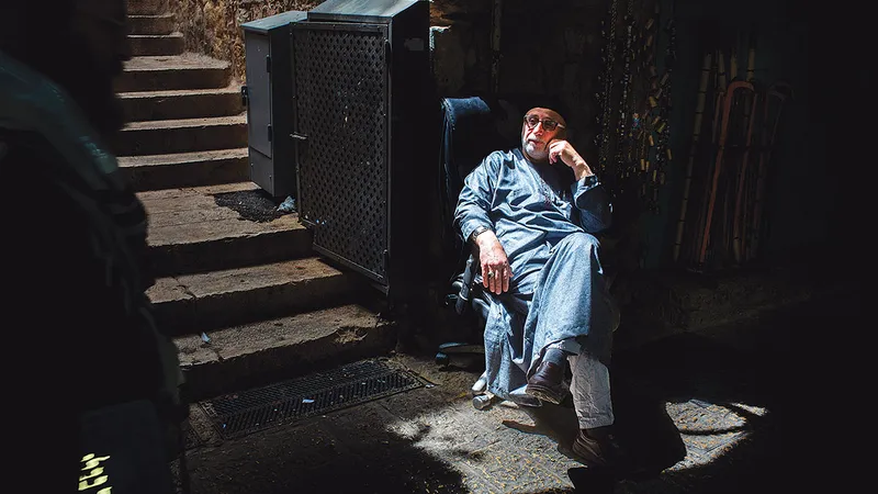 Proprietar stând în fața magazinului său, așteaptă să treacă sărbătoarea de Pesah la Ierusalim (18 aprilie 2022)
