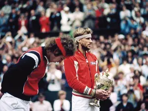 Björn Borg ținând în brațe cupa de argint acordată învingătorului de la Wimbledon. Lângă el, John McEnroe, marele învins