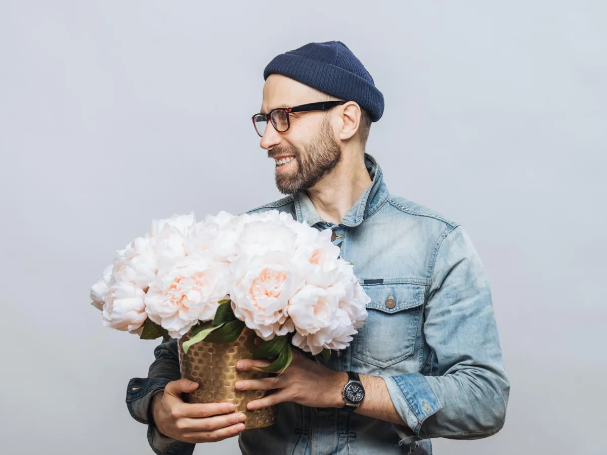 Bărbat cu buchet de flori albe - Foto: Magnific.com (Imagine cu rol ilustrativ)