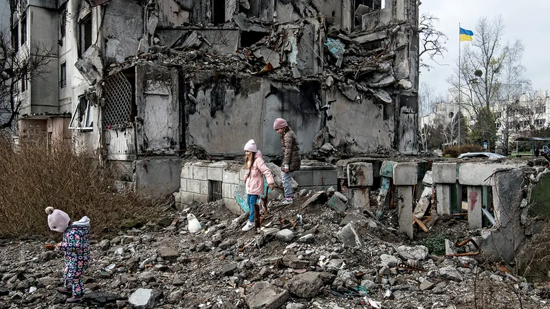 Tinerii explorează dărâmăturile unei clădiri distruse în noiembrie 2022, în Borodyanka, lângă Kiev