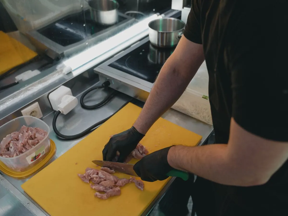 Bărbat care taie carne crudă pe o tavă - Foto: Pexels (Imagine cu rol ilustrativ)