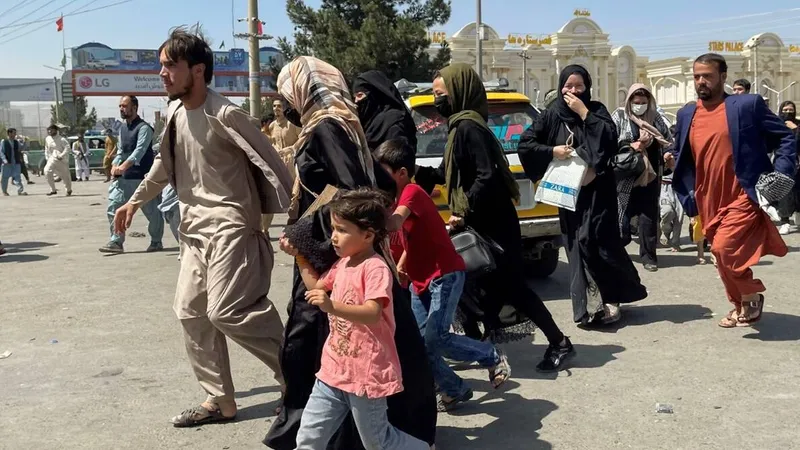 Mamele disperate îşi aruncă copiii peste gardul de la Kabul, implorând soldații să îi salveze/FOTO: indianexpress