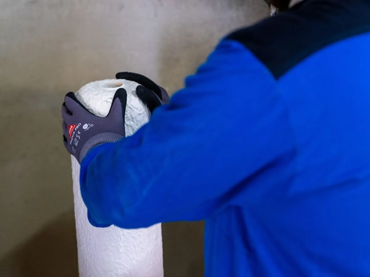 Un angajat Rheinmetall lucrează la o piesă brută, mată, combustibilă, turnată într-o mașină - Foto: Profimedia Images