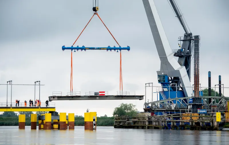 O secțiune avariată a podului feroviar peste râul Hunte , recuperată cu ajutorul unei macarale - Foto: Profimedia Images