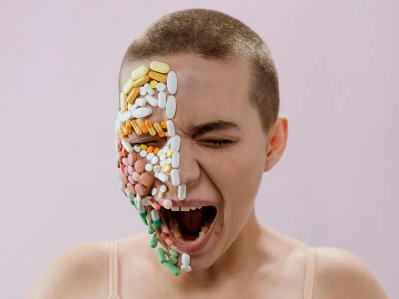 Femeie cu jumătatea dreaptă a obrazului acoperită de pastile de diferite culori - Foto: Pexels/cottonbro studio