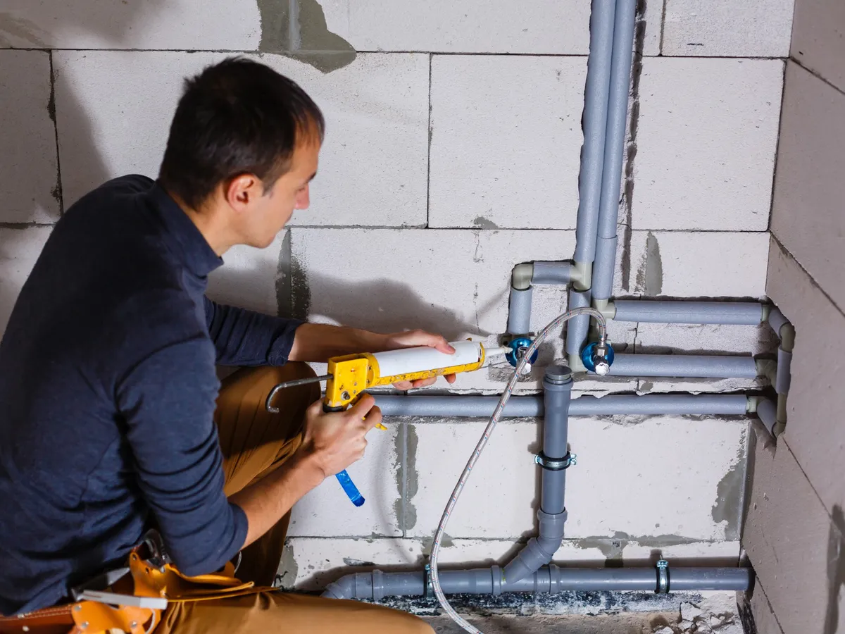Bărbat care repară o conductă - Foto: Freepik (Imagine cu rol ilustrativ)