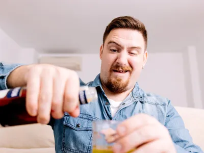 Bărbat care toarnă alcool într-un pahar - Foto: Freepik (imagine cu rol ilustrativ)