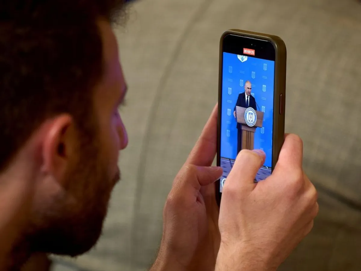 Un jurnalist înregistrează pe telefonul său conferinţa de presă a preşedintelui ad-interim Ilie Bolojan - Foto: Profimedia Images