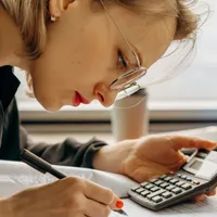 Femeie adâncită în calcule complicate - Foto: Pexels/Mikhail Nilov