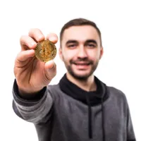 Bărbat care ține o criptomonedă în mână - Foto: Freepik (Imagine cu rol ilustrativ)