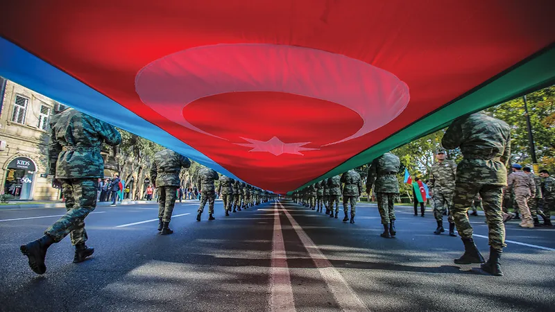 O PACE DE SCURTĂ DURATĂ Membrii serviciilor azere poartă un steag uriaș într-o procesiune în noiembrie anul trecut, care marchează un an de la încheierea conflictului militar cu Armenia.
