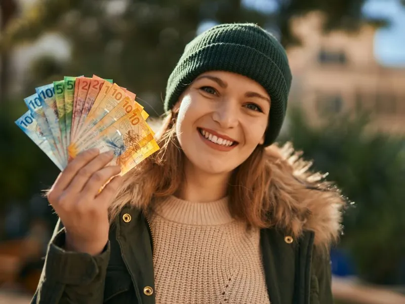 Fată cu un evantai de bancnote euro - Foto: Freepik/krakenimages.com