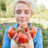 Femeie ținând câteva roșii - Foto: Pexels (cu rol ilustrativ)