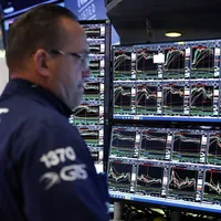 Trader uitându-se consternat, pe 10 aprilie, cum toate graficele de evoluţie indică o bursă New York Stock Exchange pe roşu - Foto: Profimedia Images