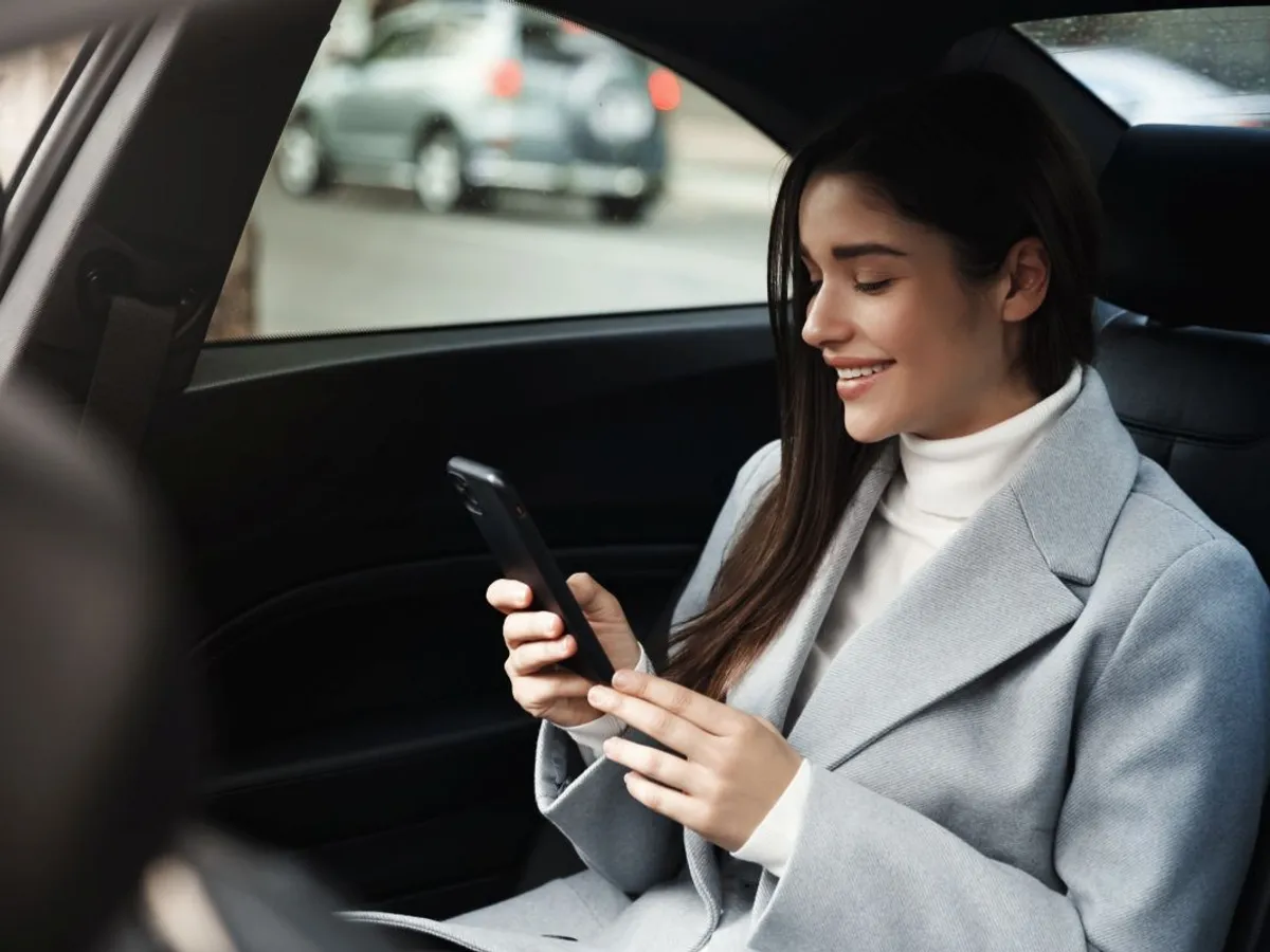 Femeie zâmbitoare făcând ride-hailing - Foto: magnific.com/lookstudio