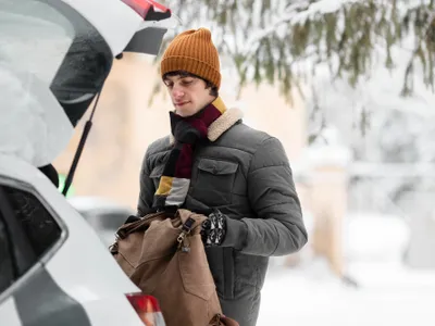 Bîrbat îmbrăcat gros lângă mașină - Foto: Freepik (rol ilustrativ)