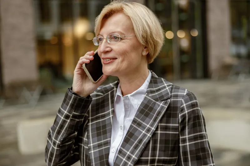 Pensionară la pensie vorbește la mobil - Foto: Freepik