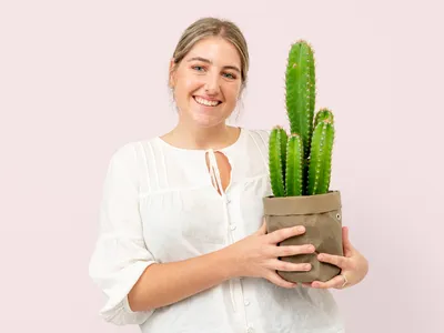 Femeie care ține în mână un ghiveci cu cactuși - Foto: Freepik (Imagine cu rol ilustrativ)