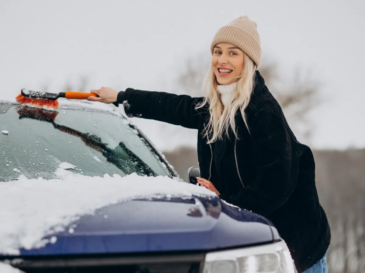 Femeie curăță mașina de zăpadă - Foto: Freepik (rol ilustrativ)