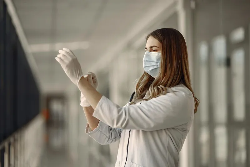 Cadru medical purt&acirc;nd mască şi mănuşi de protecţie - Foto: Pexels/Gustavo Fring