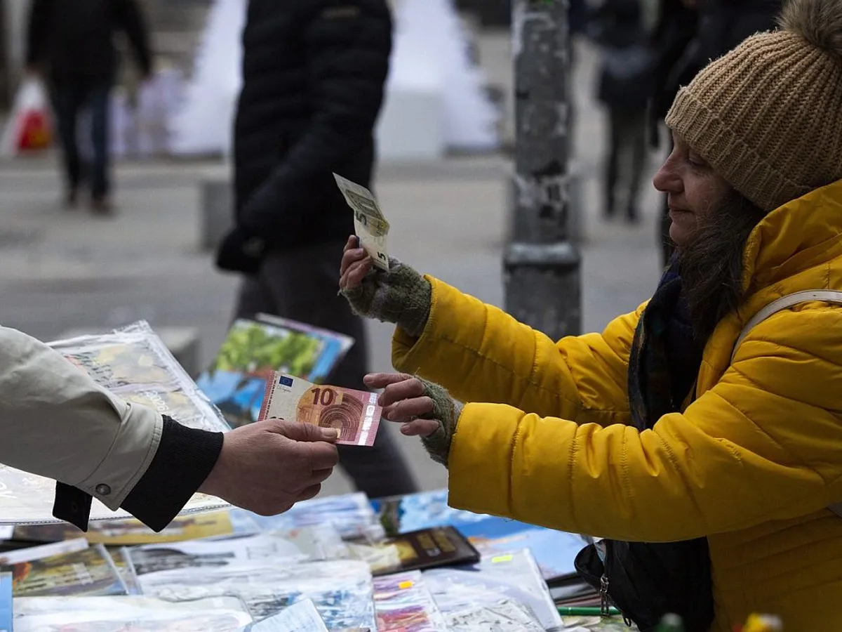 Clienții unei piețe în aer liber din Sofia plătesc cu bancnote euro, odată cu adoptarea oficială a monedei euro, de către Bulgaria - Foto: Profimedia Images