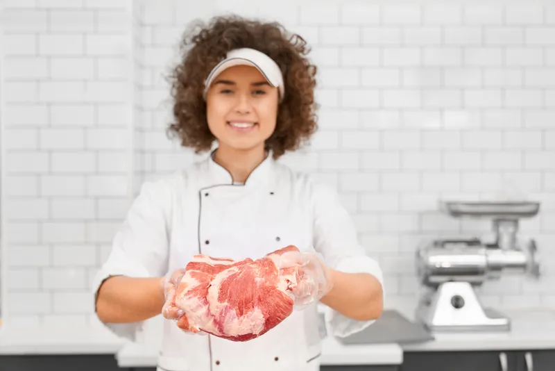 Femeie cu o bucată de carne - Foto: Magnific.com (Imagine cu rol ilustrativ)