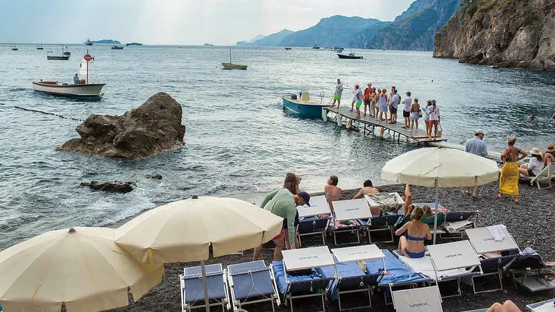 Oameni pe plaja Da Adolfo, unul dintre cele mai renumite restaurante de pe Coasta Amalfitană, în Positano Foto: Mugur Vărzariu