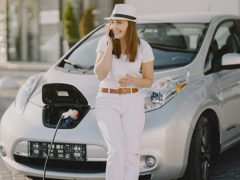 Femeie așteptând mașina electrică la încărcat - Foto: Freepik