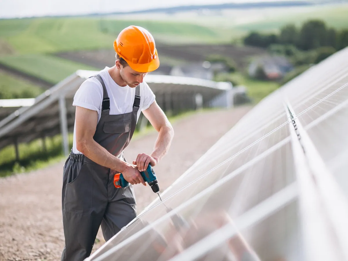 Muncitor montând panouri fotovoltaice