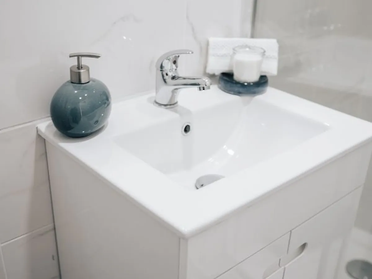 Dulap de baie alb cu chiuvetă integrată, soluție practică pentru ordine și spațiu într-o baie modernă - Foto: pexels.com