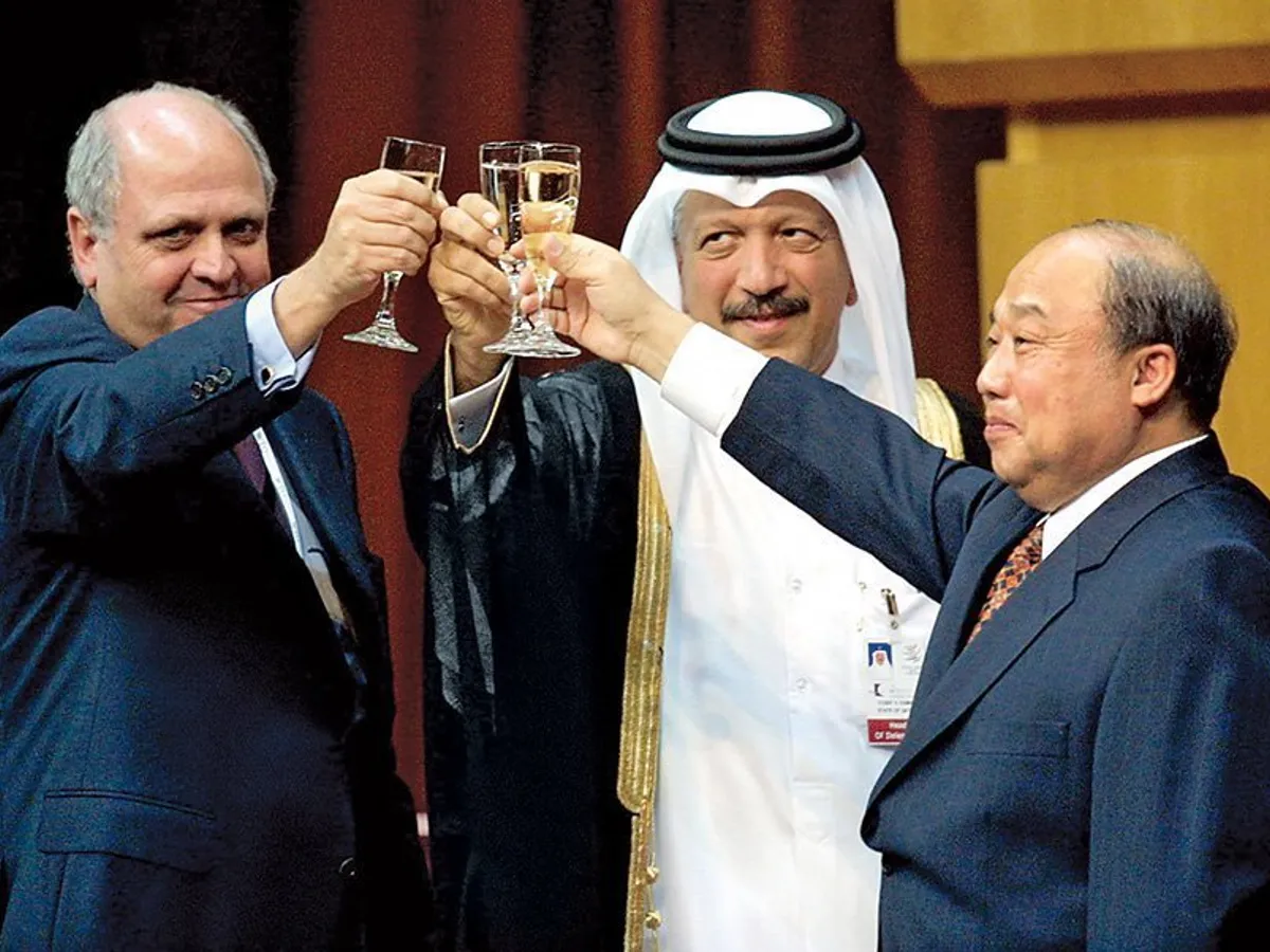 Aderarea la Organizația Mondială a Comerțului a semnalat revenirea Chinei în economia globală. Șeful OMC, Mike Moore, șeicul Yussef Hussein Kamal din Qatar și Shi Guangsheng din China, la ceremonia de semnare în 2001