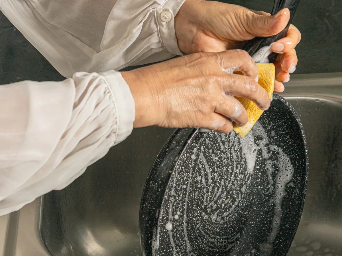 Persoană care spală o tigaie - Foto: Freepik (Imagine cu rol ilustrativ)