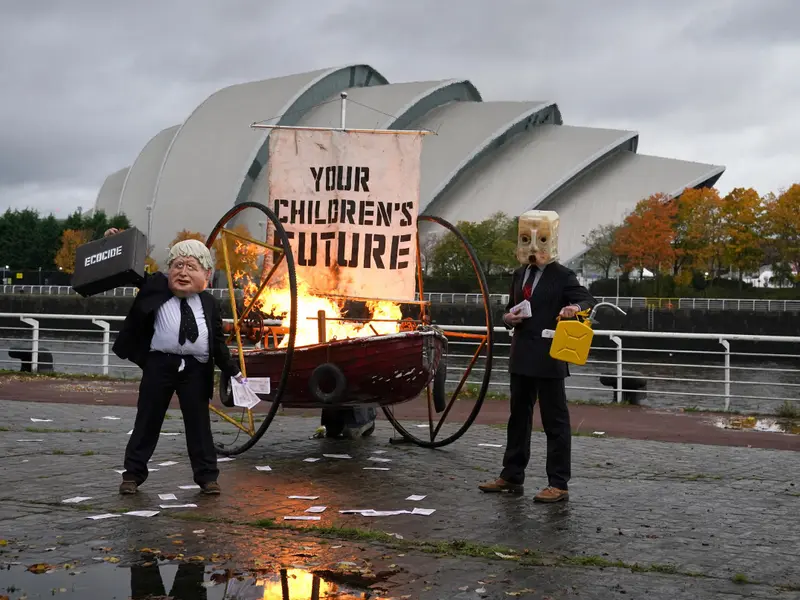 Conferinţa ONU pentru climă: un protestatar deghizat în Boris Johnson a incendiat o barcă. / Foto: thenational.scot