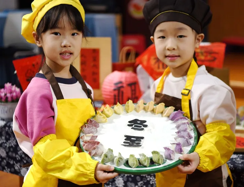 Un băieţel şi o fetiţă din China arată găluştele pe care le-au făcut la grădiniţă - Foto: Profimedia Images