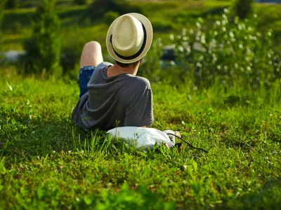Bărbat care stă pe iarbă - Foto: Magnific.com (Imagine cu rol ilustrativ)