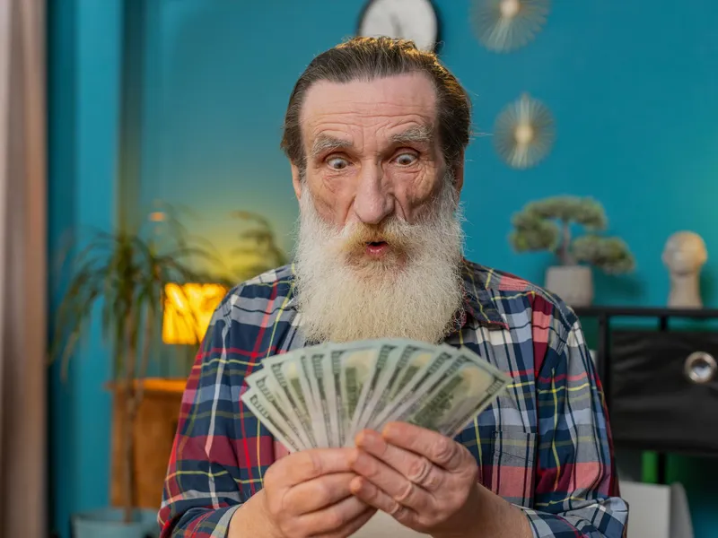 Un pensionar își numără pensia specială - Foto: Freepik