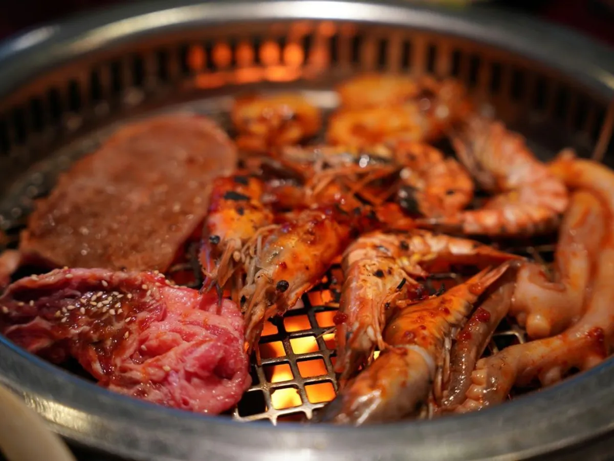 Churrasco, tradiţionalul grătar brazilian din carne de vită, este gata de mâncat. Prin grătar se văd nerăbdătoare să fie consumate şi nişte languste prăjite - Foto: Profimedia Images