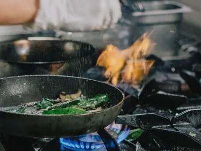 Bucătar gătind cu flacără de gaz metan, la aragaz - Foto: Pexels/Ata Ebem