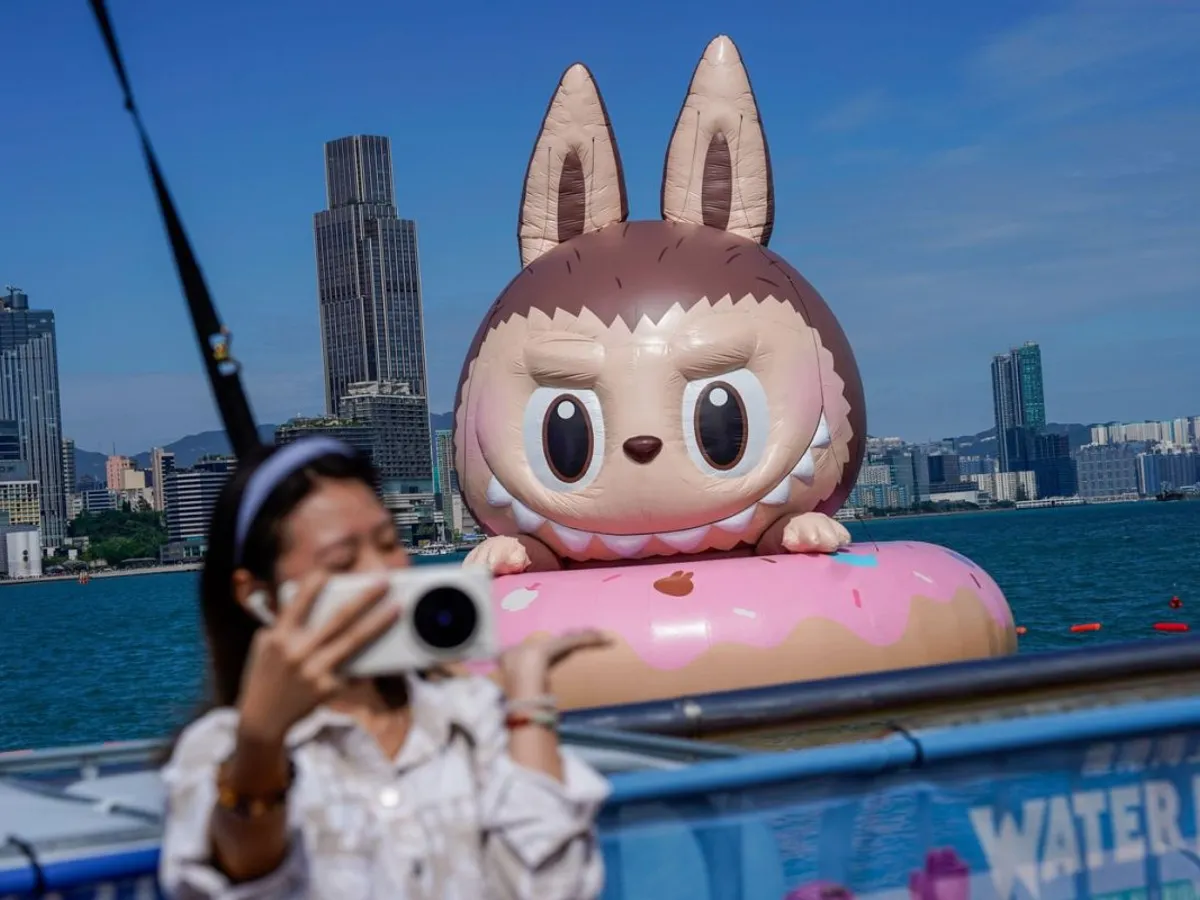 O femeie care își face un selfie cu o sculptură gonflabilă plutitoare Labubu, în Hong Kong - Foto: Profimedia Images