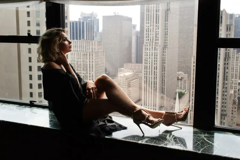 Femeie la geam - Foto: Freepik