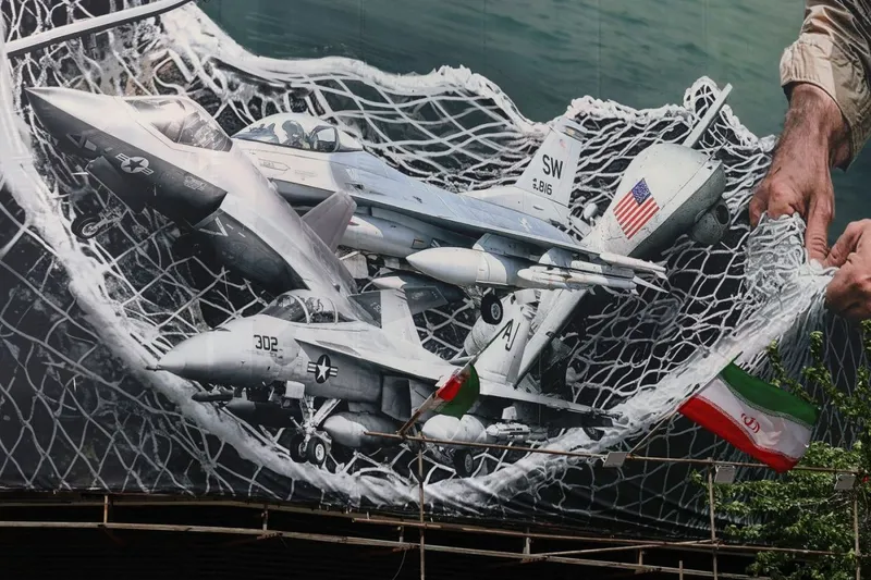 Panou publictar imens, &icirc;n Piaţa Revoluţiei din Teheran, reprezent&acirc;nd o plasă pescărească iraniană prinz&acirc;nd avioane americane - Foto: Profimedia Images