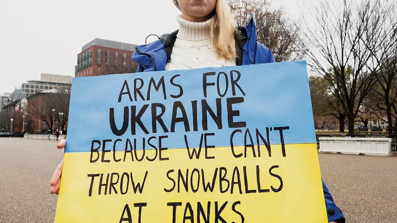 O protestatară ține o pancartă care pledează pentru ajutor pentru Ucraina, la Washington, în fața Casei Albe - Foto: Profimedia Images