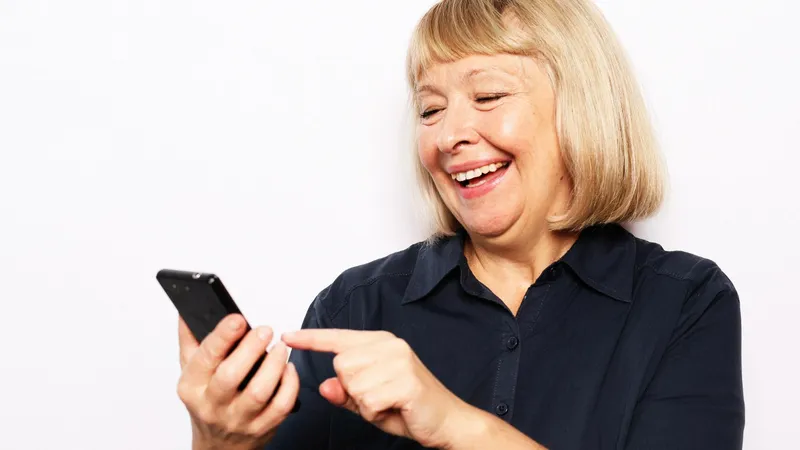 Pensionară verificând pe telefon dacă i-a intrat pensia - Foto: Freepik