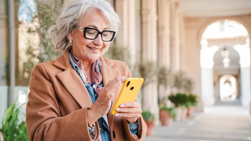Pensionară verificând pe telefon dacă i-a intrat pensia - Foto: Freepik