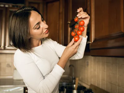 Femeie care ține roșii în mână - Foto: Freepik (Imagine cu rol ilustrativ)