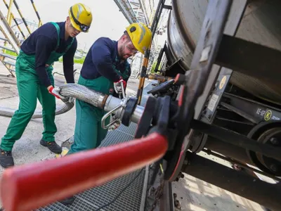 Muncitorii primesc aditiv lichid pentru rafinarea petrolului, dintr-un tren cisternă, la Rafinăria Duna a MOL - Foto: Profimedia Images