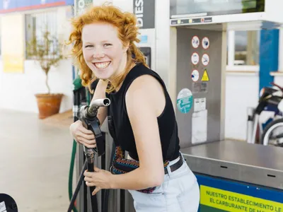 O femeie se pregăteşte să facă plinul, la pomp ade benzină - Foto: Freepik/CC0