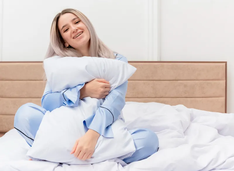 Femeie care ține o pernă în brațe - Foto: Freepik (Imagine cu rol ilustrativ)