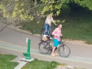 Primarul Robert Negoiță plimbându-se prin parc, pe bicicletă, cu iubita, și încâlcând astfel restricțiile de circulație Foto: Captură video